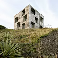 Seaside Detached Villa on Hillside with Concrete Exterior Square Windows and Illuminated Ocean View