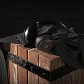 Black Over Ear Headphones Placed On Wooden Crate With Dark Cloth