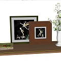 Decorative Framed Artworks with White Vase and Coffee Table Book on Wooden Shelf