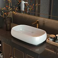 White Oval Washbasin with Golden Faucet on Dark Marble Counter and Toiletries in Modern Bathroom