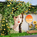 Art Installation With Female Figure Adorned By Green Vines And Yellow Sunflowers On Wall