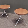 Two Stools With Brown Leather Seats And Silver Star Shaped Metal Legs On Herringbone Floor
