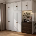Modern White Wardrobe With Golden Handles And Brown Drawer Cabinet Decorated With Plants