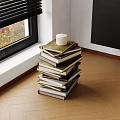 Candle Topped Stack of Books on Wooden Floor by Window with Black Blinds