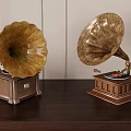 Antique Gramophones With Ornate Horns And Wooden Bases On Dark Table
