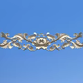 Ornate Metallic Carving With Intricate Curved Patterns And Floral Elements On Blue Background