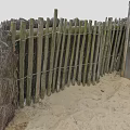 Wooden Fence Made Of Poles And Wire On Sandy Ground