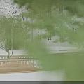 Modern Wooden Landscape Seating With Wavy Design Surrounded By Trees White Buildings And Street Lamps