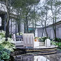 Serene Garden Landscape With Circular Platform Fire Pit Lounge Chair Water Feature And Greenery
