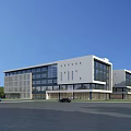 Modern Industrial Factory Building With White Exterior Large Glass Windows Parking Area And Trees