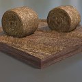 Two Round Hay Bales Placed On Square Wooden Base With Dry Straw