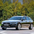 Black Audi Allroad Station Wagon With Roof Rails In Green Forest Road View