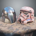 Two Stylish Helmets Metallic Silver And Pink Weathered Design On Sandy Base