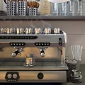 Stainless Steel Espresso Machine With Steam Cups And Bottles In Kitchen Shelf Setting