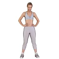 Fit Woman Wearing White Sports Bra and Leggings with Hands on Hips Against Gear Background