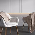Modern White Armchair With Wooden Legs And Brown Knitted Blanket Against Gray Wall Background