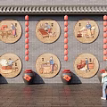 Round Framed Traditional Scene Paintings on Gray Brick Wall With Red Lanterns and Black Jars