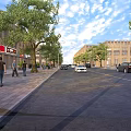 Bustling Commercial Street With Pedestrians Walking Cars Driving Trees And Buildings
