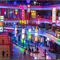 Vibrant Nighttime Commercial Landscape With Neon Signs Multi Level Buildings And Pedestrians