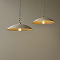 Two Modern Pendant Lights Hanging From Chains With Illuminated Bulbs Against Neutral Wall