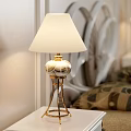 Classic Double Bed With White Carved Headboard Brown Bedspread Patterned Pillows Nightstands And Table Lamps