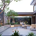 Modern Outdoor Courtyard Garden Design With Rattan Chairs Green Plants Water Feature And Natural Light