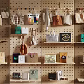 Stylish Bags and Boxes Hanging on Pegboard Wall with Shelves and Welcome Sign