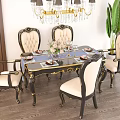 Elegant Carved Dining Table Set With Gold Accents Chandelier And Green Plant