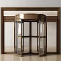 Modern Revolving Door With Brass Frame And Glass Panels In Wooden Entrance Surround