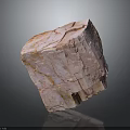 Pink Layered Stone With Wood Like Grain Texture In Irregular Block On Dark Reflective Background
