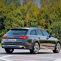 Black Audi Allroad Station Wagon With Roof Rails In Green Forest Road View