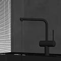 Modern Black Faucet With Water Flow Near White Blinds And Gray Wall