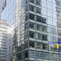 Bright Modern Commercial Storefront Window Display Along Downtown Urban Street Beneath Glass Curtain Wall Building