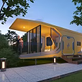 Yellow Modern Boutique Hotel Building With Glass Walls Surrounded by Trees And Outdoor Lighting