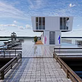 Waterfront Container Building With Staircase Wooden Platform And Small Boat On Lake
