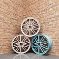 Three Silver And Blue Wheel Rims Leaning Against Brick Wall Corner On Gray Tiled Floor