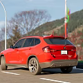 Red BMW SUV Exterior View Parked On Road With Building Background