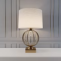 Elegant Modern Table Lamp With Fabric Shade And Brass Spherical Frame On Gray Panel Wall