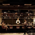 Elegant Bar Interior With Bar Counter Wine Racks High Stools Staff And Customers