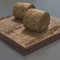 Two Round Hay Bales Placed On Square Wooden Base With Dry Straw