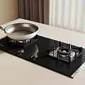 Modern Black Glass Gas Cooktop With Silver Frying Pan On Kitchen Countertop