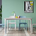 Modern Dining Table Set Featuring White Top Colorful Chairs Vase Fruits And Light Green Wall