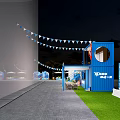 Scenic Outdoor Event Space With Triangular Tent Wooden Deck Tables Chairs Umbrellas And Grassy Area