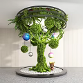 Indoor Landscape Featuring Moss Covered Tree With Hanging Colorful Spheres Small Statue And White Pebbles