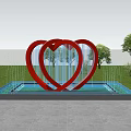 Red Double Heart Sculpture in Water Pool with Green Grass and Trees