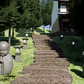 Stone Stepping Path in Garden with Green Lawn Trees Stone Lanterns and Monk Statues
