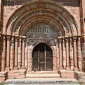 Romanesque Entrance Gate With Red Brick Structure Carved Archway Stone Columns And Wooden Doors