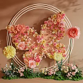 Butterfly Shaped Floral Installation With Pink Yellow Peach Flowers And Circular Frame
