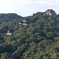Ancient Chinese Architecture On Mountain Slope With Lush Green Trees And Traditional Rooftops