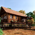 Wooden House Elevated on Stilts with Brown Roof and Natural Surroundings